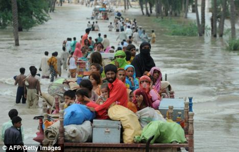 Pakistani flood survivors evacuate a flooded area in Bssera village near Muzaffargarh today